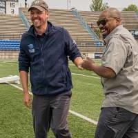 Chad Covington and Jason DeWeerd fist bumping and smiling after a cornhole victory